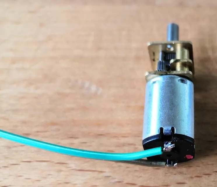 An N20 geared motor with its two wires soldered at a right angle
